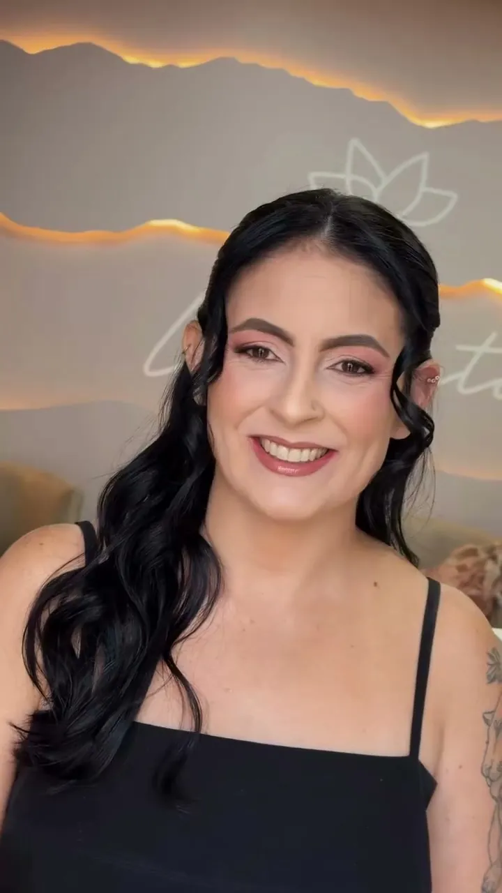 Cliente sorrindo com cabelo preto em ondas