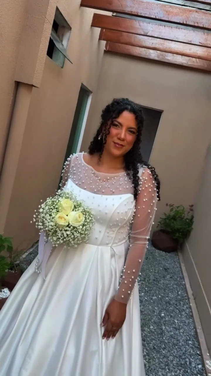 Noiva Laiane de vestido com pérolas e buquê